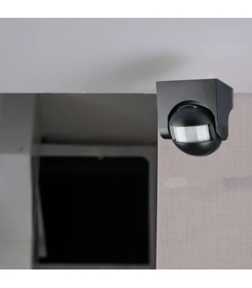 Sort udendørs bevægelsessensor monteret på væg i carport
