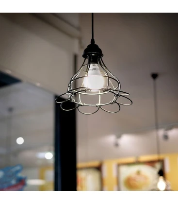 En lille E14 LED pære monteret i en lampe i et mindre rum, der giver et behageligt lys.